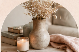 A candle, vase, and books in a soft room